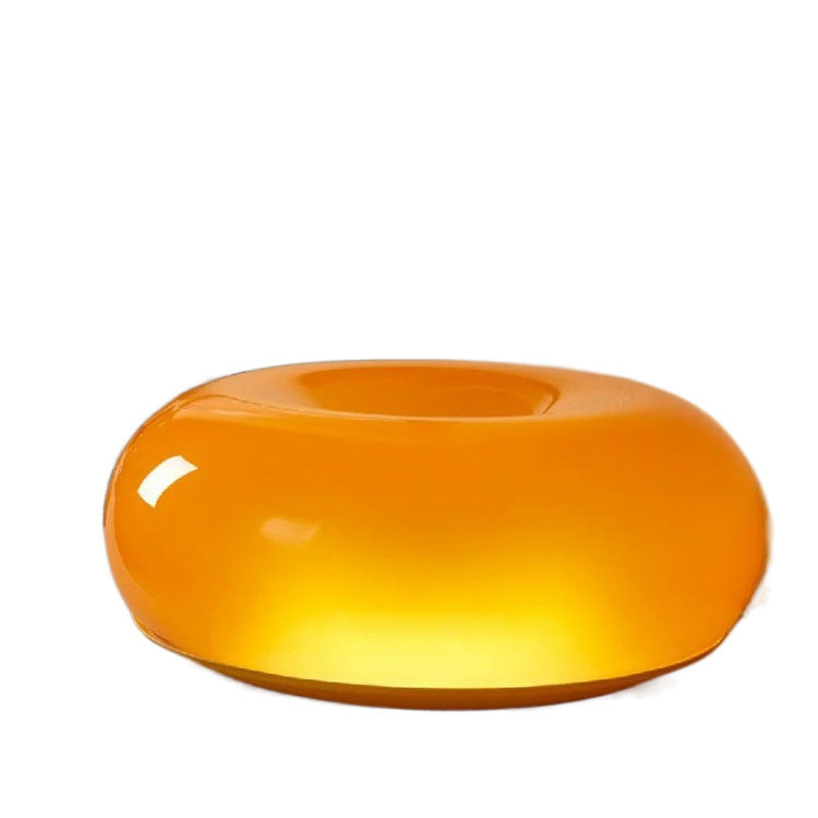 Sculptural donut lamp top view - organic torus form warm amber glow